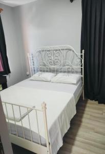 uma cama branca num quarto com uma cortina preta em paşa konağı konaklama em Ancara