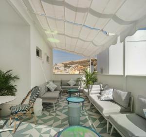 a living room with couches and tables and a ceiling at Dormirdcine Alicante in Alicante