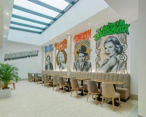 a room with tables and chairs and a mural on the wall at Dormirdcine Alicante in Alicante