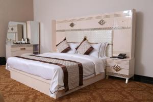 1 dormitorio con 1 cama grande y espejo grande en The Grand Mountain Hotel, en Matale
