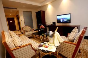 a living room with a table and a television at The Grand Mountain Hotel in Matale