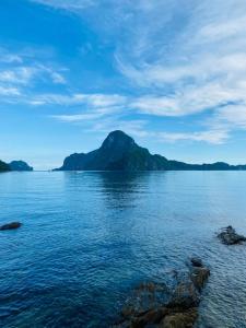 a mountain in the middle of a large body of water at Ricos Beach Cottages in El Nido