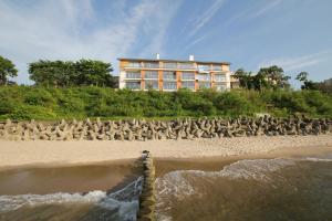 a group of birds on a beach with a building at Apartamenty Na Klifie in Ustronie Morskie