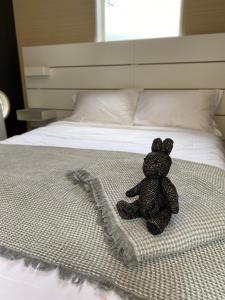 a teddy bear sitting on top of a bed at En- Hostel & Café bar in Amami