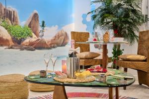 a table with food and wine glasses in a room with a painting at Sablotin SPA in Toulouse