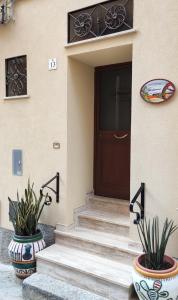 a front door of a house with two potted plants at A Cantunera LittleHouse in Agrigento