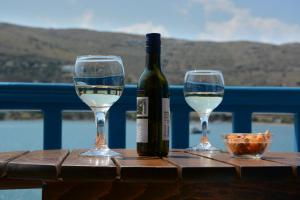 a bottle of wine and two glasses on a table at Galaxy Hotel in Gavrio