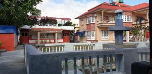 un bâtiment avec piscine d'eau en face d'un bâtiment dans l'établissement London House Resort, à Birātnagar