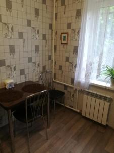リペツクにあるCentral Apartment on Papina 31Bのダイニングルーム(テーブル、椅子、窓付)