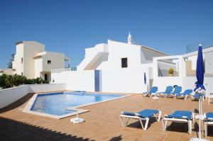 een zwembad met ligstoelen en een zwembad bij Albufeira Mar Vilas in Albufeira