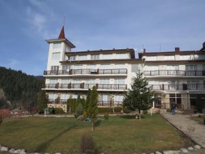 a large white building with a tree in front of it at Panoramic Apartment 301 in Eagle Rock Complex in Beli Iskar