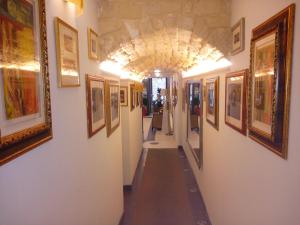 
a room with a wall of paintings on the wall at Hotel Vittorio Emanuele in Sassari
