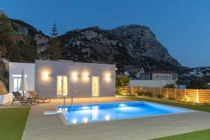 a villa with a swimming pool in front of a mountain at Villa Neonis in Spílion