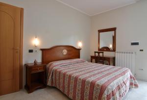 a bedroom with a bed and a dresser and a mirror at Albergo Villa Bianca in San Giovanni Rotondo