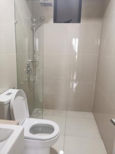 a white bathroom with a toilet and a shower at Aishiteru Homestay in Kuala Lumpur