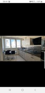 cocina con armarios blancos, mesa y sillas en Appartement Laurent Bonnevay en Villeurbanne