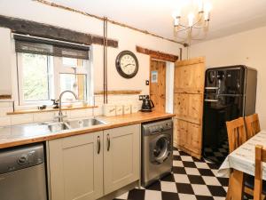 a kitchen with a sink and a refrigerator at Valentine Cottage in Aylsham
