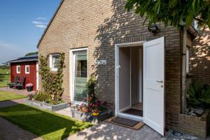 a brick house with a large white door at At MarRies in Wilp