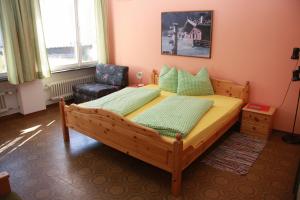 a bedroom with a wooden bed and a chair at Appartementhaus Sabine in Obertilliach