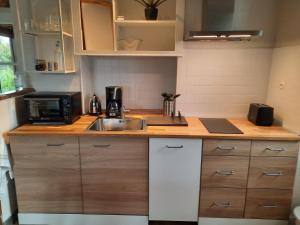 a kitchen with a sink and a microwave at Maison avec jardin dans petit bourg typiquement Percheron - Le Colombier in Boissy-Maugis +5 photos