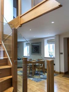 uma sala de estar com uma mesa de jantar e uma escadaria em The Manor Barn em Northampton