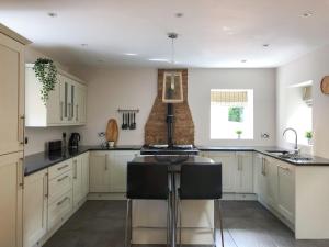 a kitchen with white cabinets and black counter tops at The Manor Barn in Northampton