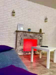 Habitación con mesa blanca y chimenea de ladrillo. en Квартира в центре (р-н Аян Пассаж), en Temirtaū