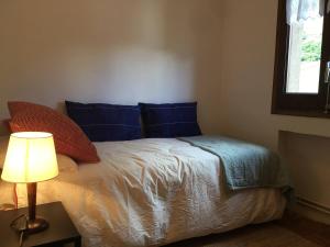 1 dormitorio con 1 cama con almohadas azules y lámpara en Apartament familiar - Els Encantats - Espot, en Espot