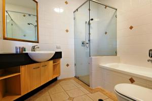 a bathroom with a sink, toilet and shower at Santorini Twin Waters in Mudjimba
