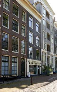 un gran edificio de ladrillo con ventanas en una calle en The Townhouse Hotel, en Ámsterdam