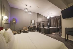 ポドゴリツァにあるBoscovich Boutique Hotelのベッドとバスルーム付きのホテルルームです。
