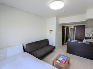 um quarto com uma cama, um sofá e uma mesa em CIEL BLEU em Tóquio