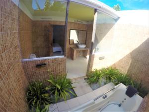 a bathroom with a tub and a toilet and a sink at Midsummer Thulusdhoo in Thulusdhoo