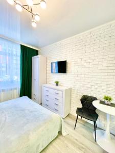 Schlafzimmer mit einem Bett, einem Tisch und einem TV in der Unterkunft Green room в ЖК Рич Таун Ирпень in Irpin