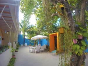 a courtyard with a table and chairs and a tree at Midsummer Thulusdhoo in Thulusdhoo