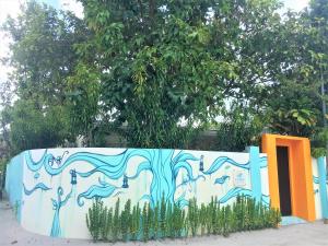 a wall with a painting of people on it at Midsummer Thulusdhoo in Thulusdhoo