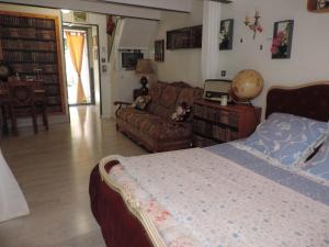 a bedroom with a bed and a couch at Chez Papy et Mamy in Saint-Chef