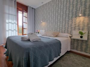 a bedroom with a bed with two pillows on it at Apartamentos Ria de Aldan in Aldán +133 photos