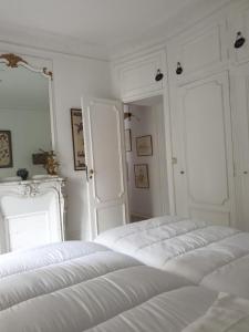 a white room with three white beds in it at CHARMING FLAT -PRIVATE AVENUE - 16 TH in Paris