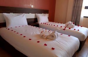 Deux lits avec des cœurs de valentine au-dessus dans l'établissement KILIMANI BREEZE HOTEL, à Wote