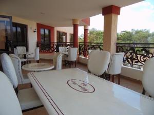 uma sala de jantar com uma mesa e cadeiras brancas em KILIMANI BREEZE HOTEL em Wote