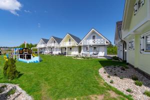 a row of houses with a playground in the yard at Domki letniskowe Otulone Słońcem in Rowy