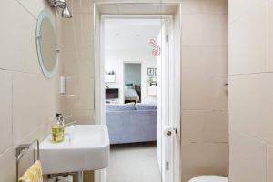 a bathroom with a sink and a mirror at The Old Post Office Apartment in Falmouth +24 photos