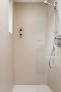 a shower with a glass door in a bathroom at The Old Post Office Apartment in Falmouth