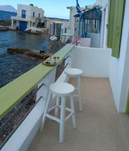 a bar on a balcony with two stools at Milos By The Sea - Eco House in Areti