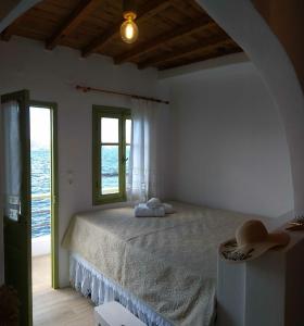 Un dormitorio con una cama grande y una ventana en Milos By The Sea - Eco House en Kástron