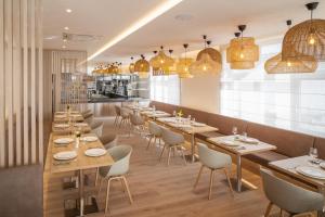 a restaurant with wooden tables and chairs and lights at Hotel U Kaplicky in Písek