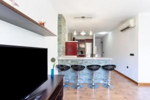 eine Küche mit vier Barhockern vor einer Theke in der Unterkunft Home2Book Bright Center Apartment Santa Cruz in Santa Cruz de Tenerife