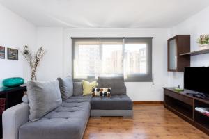 ein Wohnzimmer mit einem grauen Sofa und einem Kuhkissen in der Unterkunft Home2Book Bright Center Apartment Santa Cruz in Santa Cruz de Tenerife