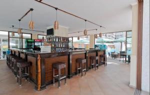 a bar in a restaurant with bar stools at Grand Kamelia Holiday Apartments in Sunny Beach